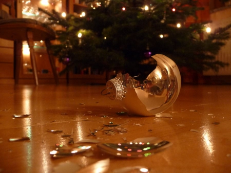 Smashed Christmas bauble on floor next to Christmas tree